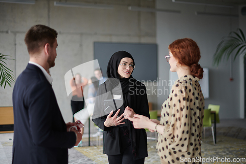 Image of A group of young business entrepreneurs engages in a lively discussion within the office, exemplifying the spirit of teamwork, innovation, and ambition in pursuit of success.