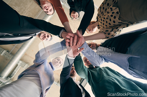 Image of A group of businessmen holding hands together to symbolize unity and strength