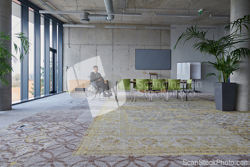 Image of Businessman in a wheelchair in a modern office lonely after a busy day