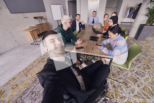 Image of In a modern office, a group of businessmen gathers around a table during a meeting, capturing a moment of camaraderie and teamwork as they take a selfie