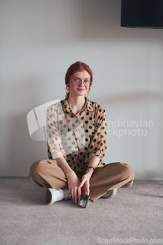 Image of A young and fashionable businesswoman sitting and taking a moment to relax while using her smartphone.