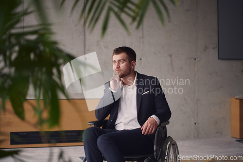 Image of A melancholic businessman in a wheelchair sitting with a sad expression, gazing through the window of a modern office, conveying a sense of solitude