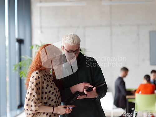 Image of In a modern and spacious office a team of business colleagues are seen diligently working together, using a laptop to analyze data and statistics