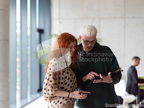 Image of In a modern and spacious office a team of business colleagues are seen diligently working together, using a laptop to analyze data and statistics