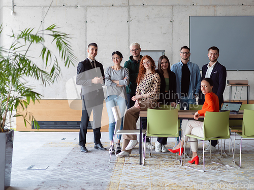 Image of A diverse group of successful businesspeople gather and pose for a photo, showcasing teamwork and professional empowerment in a modern office setting.