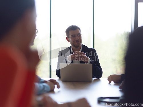 Image of A diverse group of business professionals gathered at a modern office for a productive and inclusive meeting