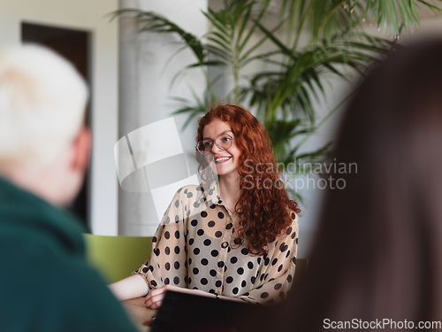 Image of A diverse group of business professionals gathered at a modern office for a productive and inclusive meeting