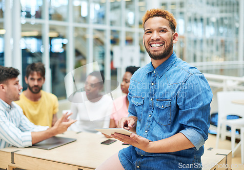 Image of Our results speak for themselves. a young businessman using a digital tablet during a team meeting in a modern office.