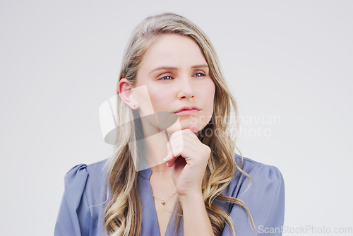 Image of Ive been doing some thinking about this...Studio shot of a young woman looking thoughtful against a gray background.