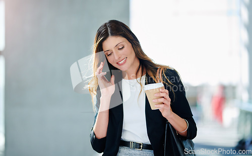 Image of Business is about calling the right people. an attractive young businesswoman taking a a phonecall while walking through a modern office.