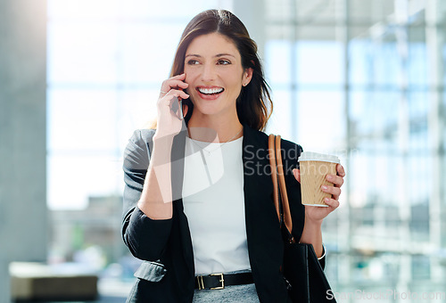 Image of Thats awesome news. an attractive young businesswoman taking a a phonecall while walking through a modern office.