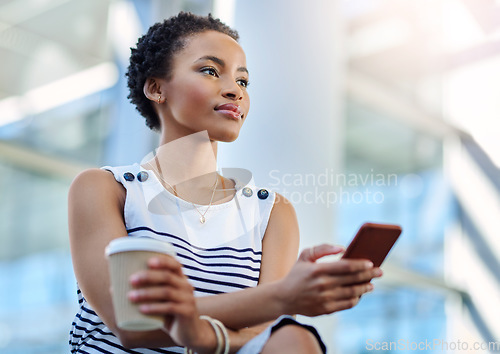 Image of Business mindedness Activated. an attractive young businesswoman looking thoughtful while using a smartphone in a modern office.
