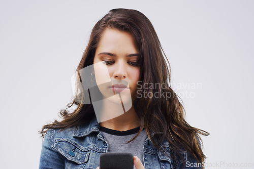 Image of Bored Jump online. a young woman reading something on her cellphone.