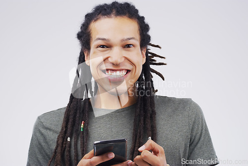 Image of The cyber world gives us the confidence to get the girl. Studio shot of a happy young man using his cellphone.