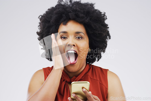 Image of Online shopping is one of the big advantages of the internet. Studio shot of a young woman looking surprised while reading something on her cellphone.