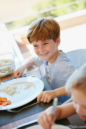 Image of Lunchtime. a little boy enjoying a meal with his family at home.