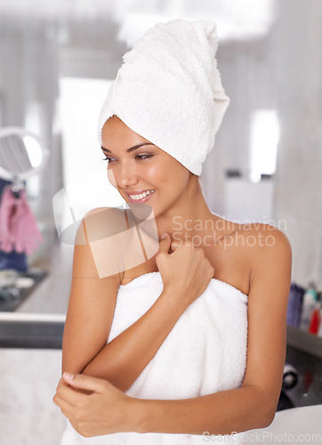 Image of As close to feminine as it gets. a beautiful young woman standing in the bathroom in a towel.