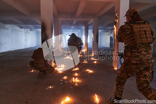 Image of A group of professional soldiers bravely executes a dangerous rescue mission, surrounded by fire in a perilous building.