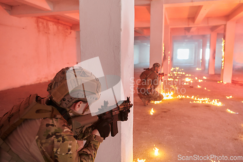 Image of A group of professional soldiers bravely executes a dangerous rescue mission, surrounded by fire in a perilous building.