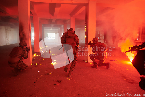 Image of A group of professional soldiers bravely executes a dangerous rescue mission, surrounded by fire in a perilous building.