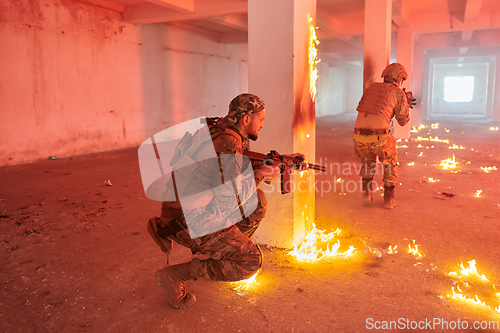 Image of A group of professional soldiers bravely executes a dangerous rescue mission, surrounded by fire in a perilous building.