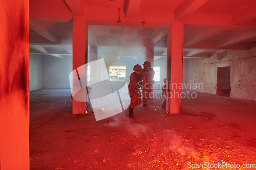 Image of A group of professional soldiers bravely executes a dangerous rescue mission, surrounded by fire in a perilous building.