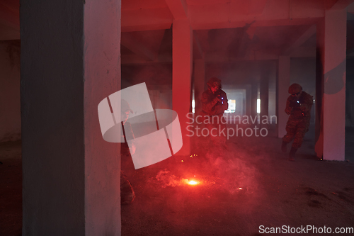 Image of A group of professional soldiers bravely executes a dangerous rescue mission, surrounded by fire in a perilous building.