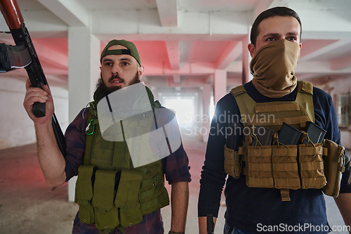 Image of An abandoned building serves as the stronghold for a team of terrorists, fiercely guarding their occupied territory with guns and military equipment