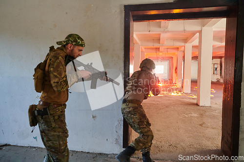 Image of A group of professional soldiers bravely executes a dangerous rescue mission, surrounded by fire in a perilous building.