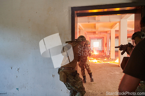 Image of A group of professional soldiers bravely executes a dangerous rescue mission, surrounded by fire in a perilous building.