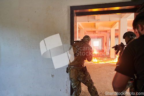 Image of A group of professional soldiers bravely executes a dangerous rescue mission, surrounded by fire in a perilous building.