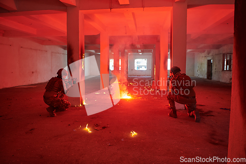 Image of A group of professional soldiers bravely executes a dangerous rescue mission, surrounded by fire in a perilous building.