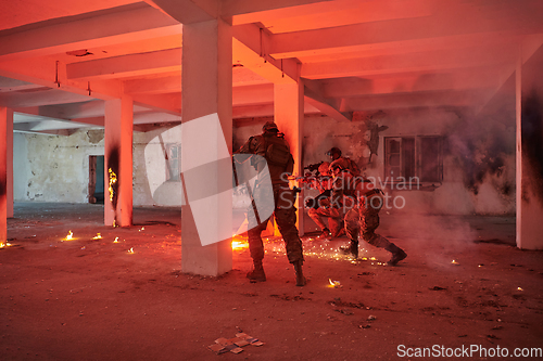 Image of A group of professional soldiers bravely executes a dangerous rescue mission, surrounded by fire in a perilous building.