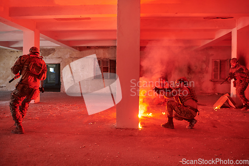 Image of A group of professional soldiers bravely executes a dangerous rescue mission, surrounded by fire in a perilous building.