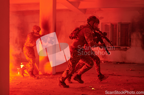 Image of A group of professional soldiers bravely executes a dangerous rescue mission, surrounded by fire in a perilous building.