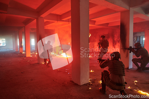 Image of A group of professional soldiers bravely executes a dangerous rescue mission, surrounded by fire in a perilous building.