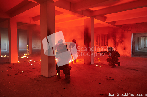 Image of A group of professional soldiers bravely executes a dangerous rescue mission, surrounded by fire in a perilous building.