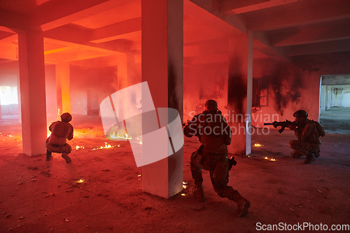 Image of A group of professional soldiers bravely executes a dangerous rescue mission, surrounded by fire in a perilous building.