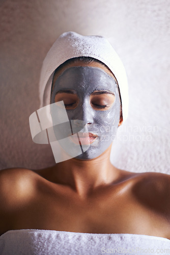 Image of Blissful beautification. a beautiful young woman relaxing during a facial treatment at a spa.