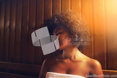 Image of Serene time in the sauna. A young woman relaxing in the sauna at a spa.