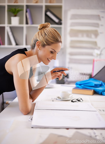 Image of Creating a masterpiece. A fashion designer working on her sketches.