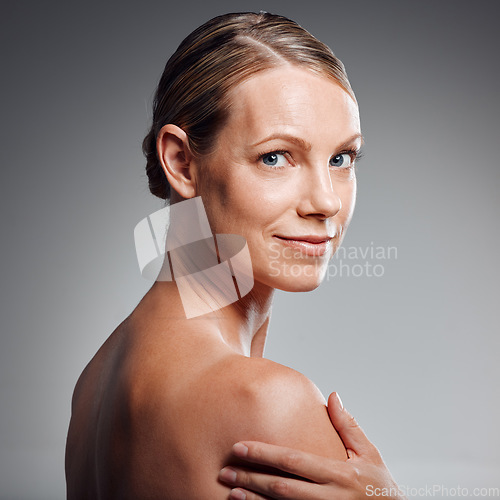 Image of Beautiful mature woman posing in studio against a grey background