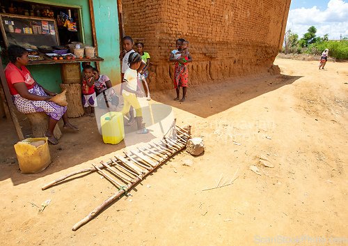 Image of Malagasy woman resting in front of market in shadow. Vohitsoaka Ambalavao, Madagascar