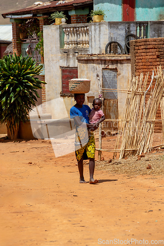 Image of Woman carrying child on her back in Vohitsoaka Ambalavao, Madagascar