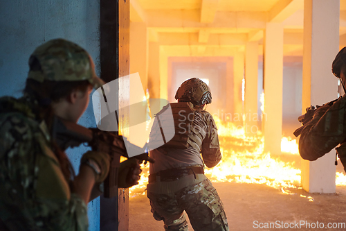 Image of A group of professional soldiers bravely executes a dangerous rescue mission, surrounded by fire in a perilous building.