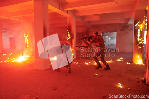 Image of A group of professional soldiers bravely executes a dangerous rescue mission, surrounded by fire in a perilous building.