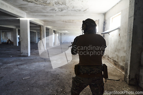 Image of A professional soldier in an abandoned building shows courage and determination in a war campaign