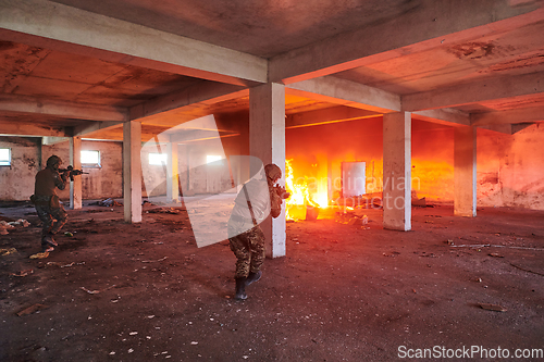 Image of A group of professional soldiers bravely executes a dangerous rescue mission, surrounded by fire in a perilous building.