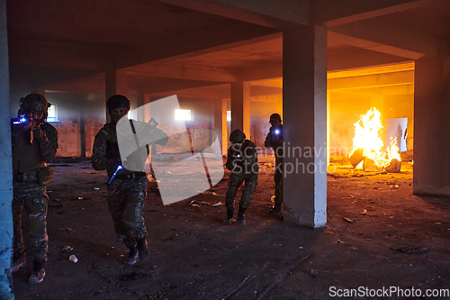 Image of A group of professional soldiers bravely executes a dangerous rescue mission, surrounded by fire in a perilous building.