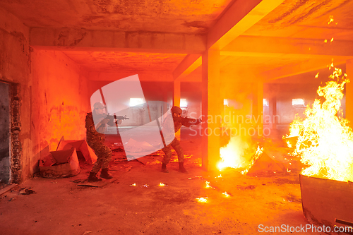 Image of A group of professional soldiers bravely executes a dangerous rescue mission, surrounded by fire in a perilous building.